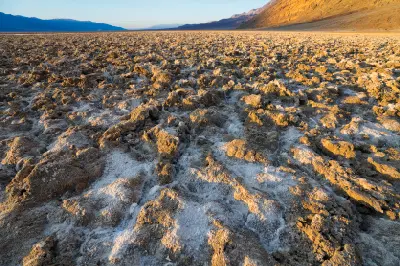 Devils Golf Course salt formations at sunset in Death Valley National Park California with rugged salt textures and warm light