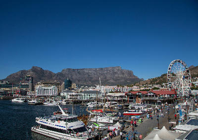 V&A Waterfront marina with boats, ferris wheel and Table Mountain in Cape Town, South Africa.