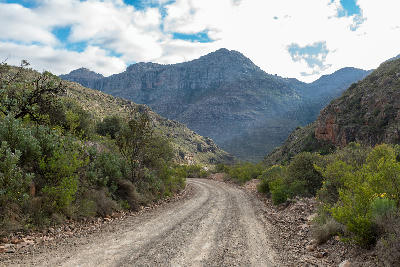Gravel road on Uitkyk Pass between steep sandstone slopes in the central Cederberg.