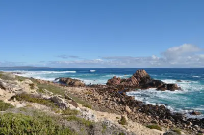 Rugged granite coastline and breaking ocean waves near Sugarloaf Rock at Cape Naturaliste, Western Australia.