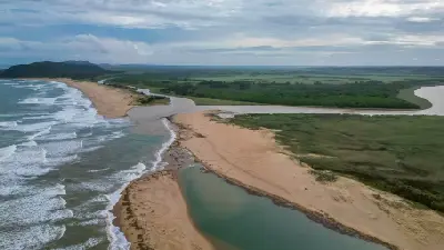 Drone view of the St Lucia Estuary mouth, showing sandbanks, wetlands and the Indian Ocean coastline in iSimangaliso Wetland Park, South Africa.