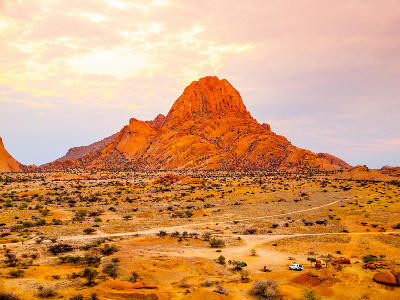 Granite mountain formation of Spitzkoppe rising above the desert landscape of Namibia at sunset.