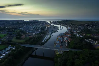 Aerial view of Whitby, the River Esk, harbour, marina and surrounding town at dusk on the North Yorkshire coast, England.