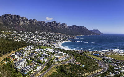 Atlantic Seaboard coastline near Camps Bay, with the Twelve Apostles mountains rising above the narrow urban strip along the ocean.