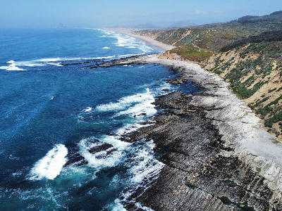 Aerial view of rugged sandstone coastline and waves at Montaña de Oro State Park on California’s Central Coast.