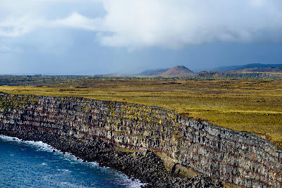 Stratified basalt cliffs of Krýsuvíkurberg on the Reykjanes Peninsula, Iceland, rising above the North Atlantic Ocean.