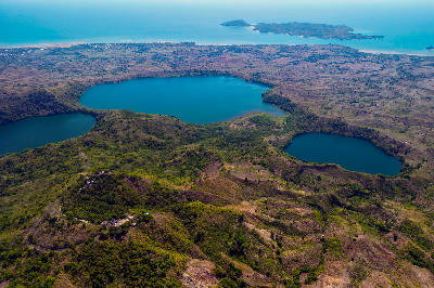 Aerial landscape of Mont Passot crater lakes on Nosy Be in Madagascar with volcanic terrain and Indian Ocean coastline.