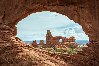 View through North Window framing Turret Arch with visitors on desert rock in Arches National Park Utah